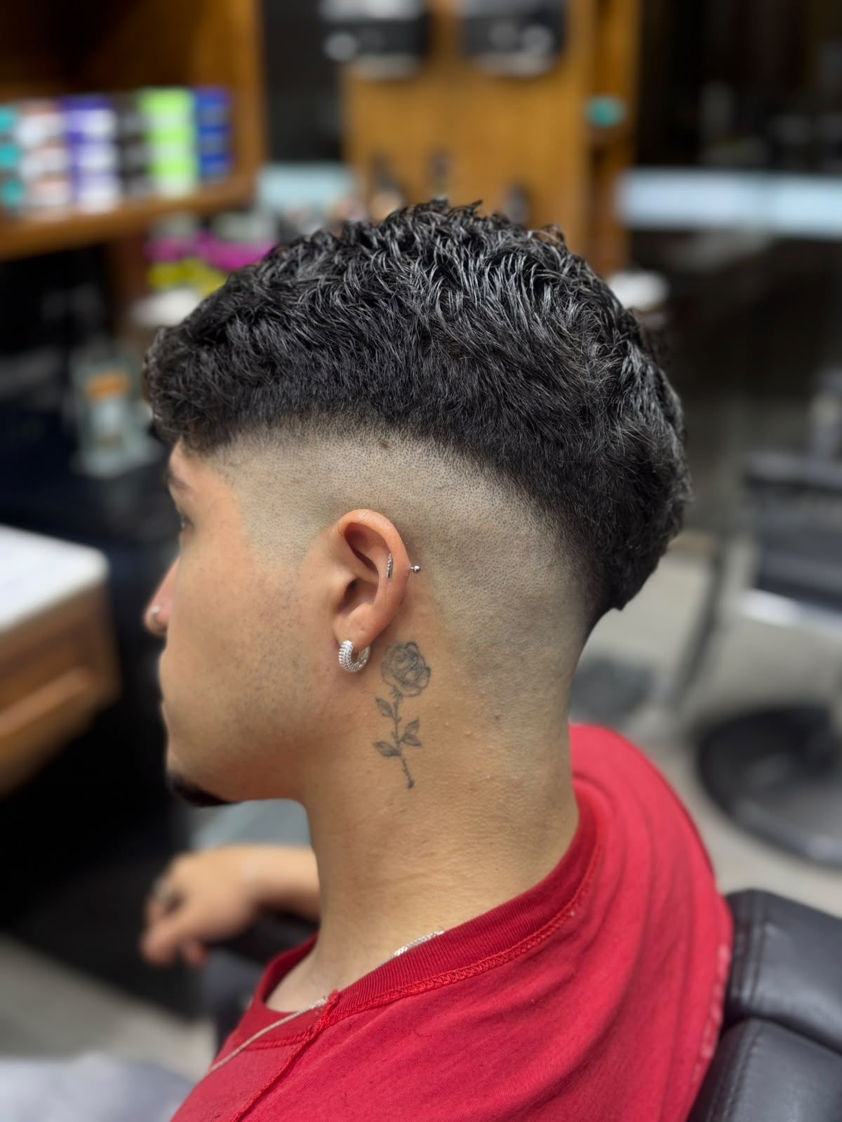 Barbeiro finalizando o corte de um cliente na Los Henrique's